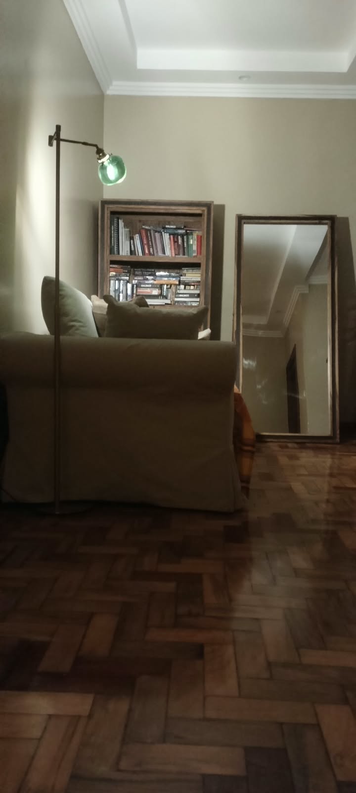 Separate supplied setting showing a green-shaded lamp beside an armchair and bookcase